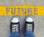 Male sneakers on the asphalt road with yellow line and title Future. Step into the future.